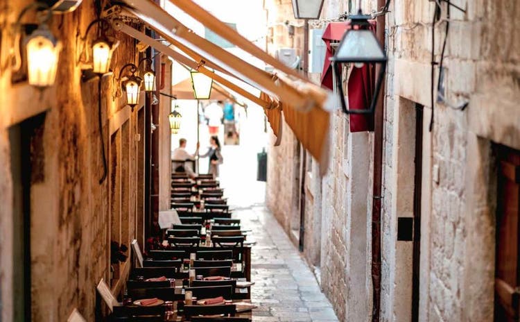 Restaurant tables along a quiet side street in Dubrovnik, Croatia