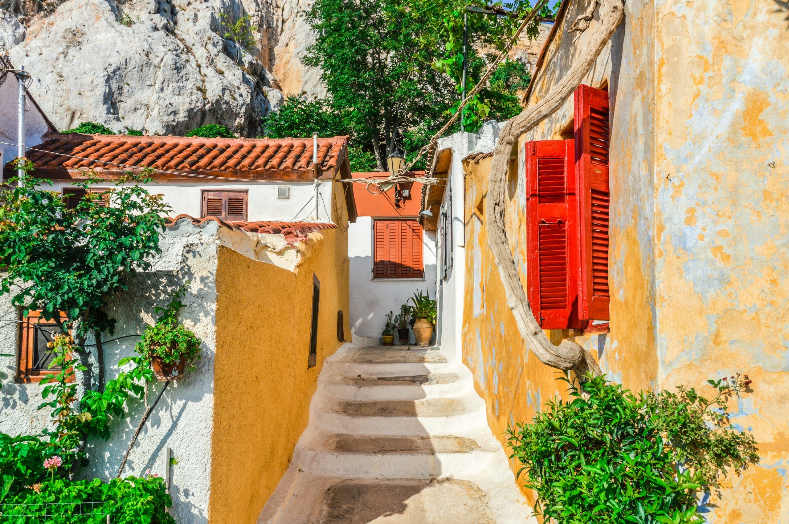 Charming alleyway in Plaka, Athens with colorful shutters and stone steps, a hidden gem on many Greek cruise excursions.