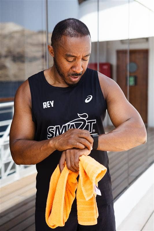 A person wearing running attire looks at their fitness tracker on their wrist