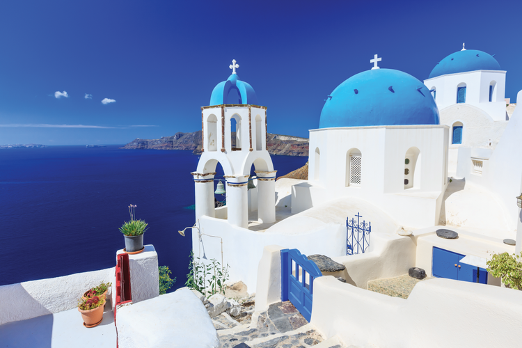 Whitewashed houses with blue domes beside the sea in Santorini, Greece