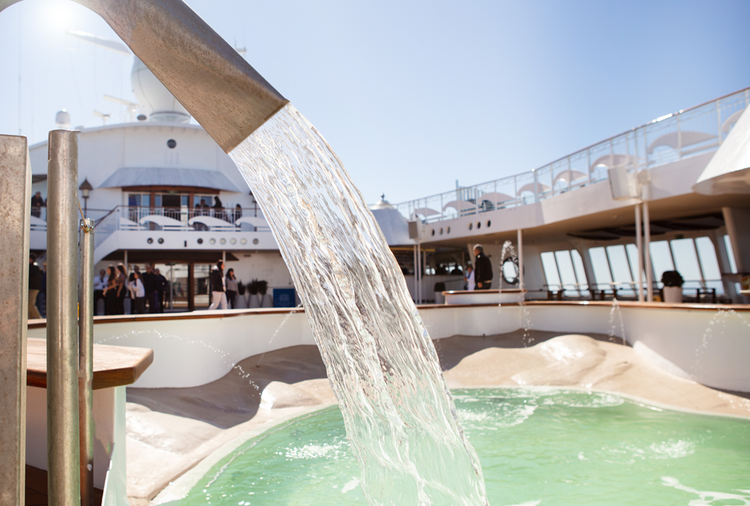 Water pours into the swimming pool on the deck of the Celestyal Discovery