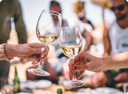 Two people raise their wine glasses to each other
