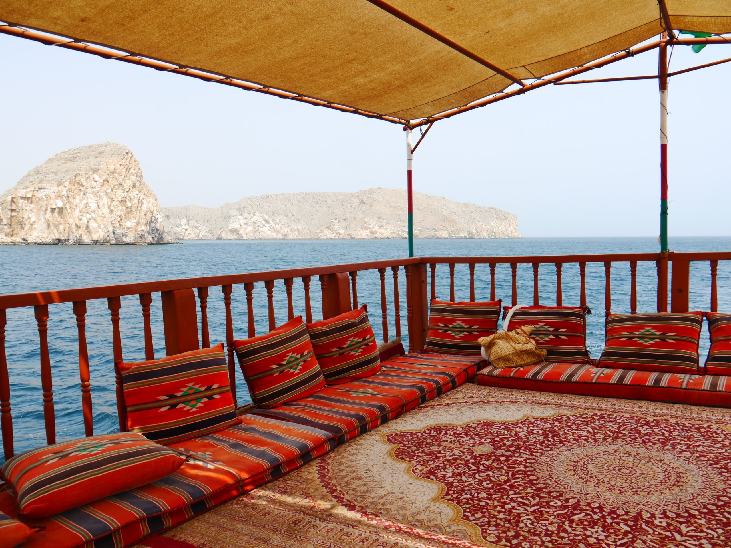 view onside a traditional dhow boat with pillows and carpet cruising the magnificant fjords of Khasab, Musandam, Oman, Middle East