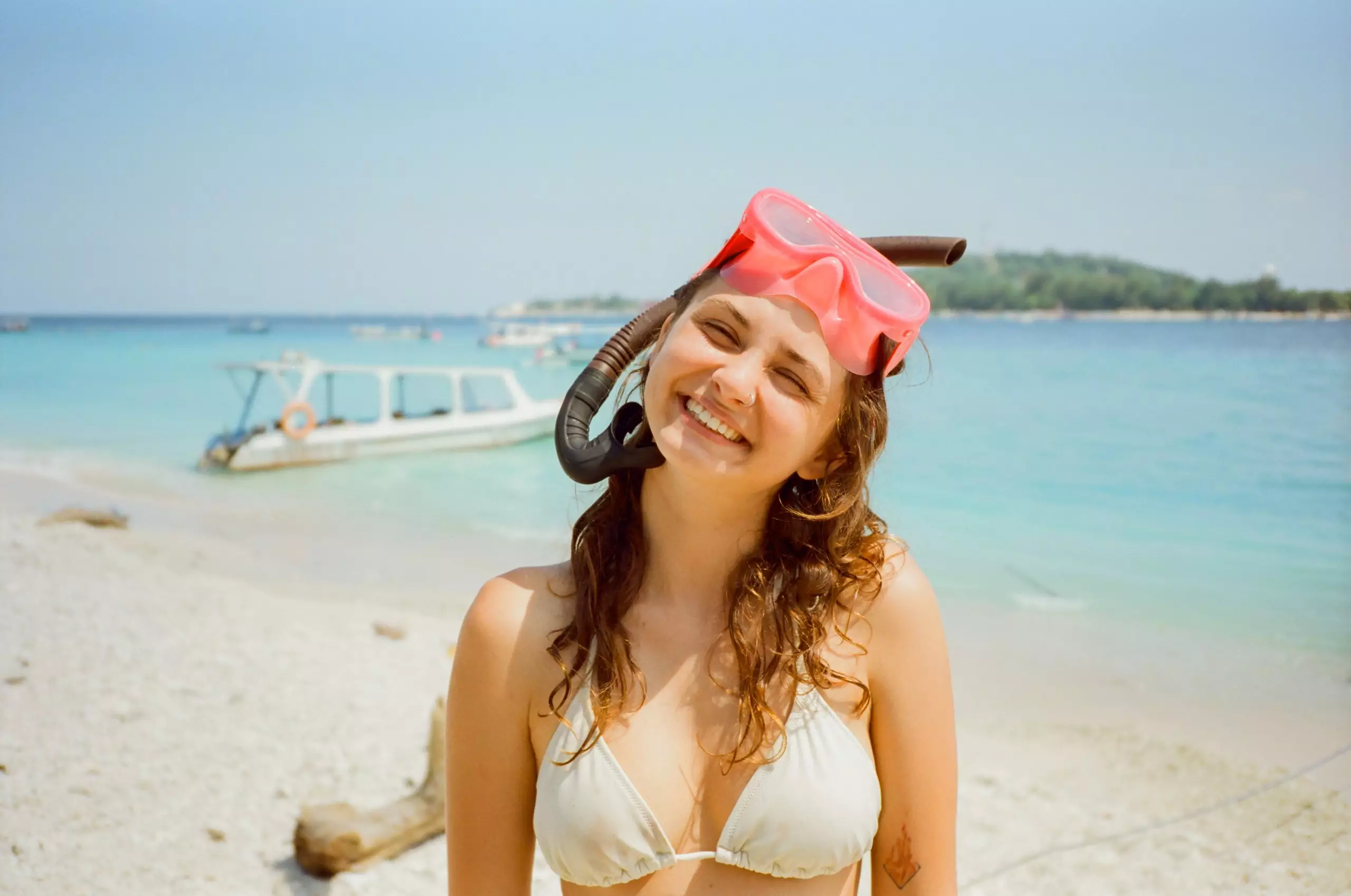 Cheerful woman standing on the beach after snorkelling